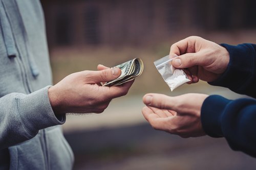Парень отдаёт деньги в обмен на наркотики